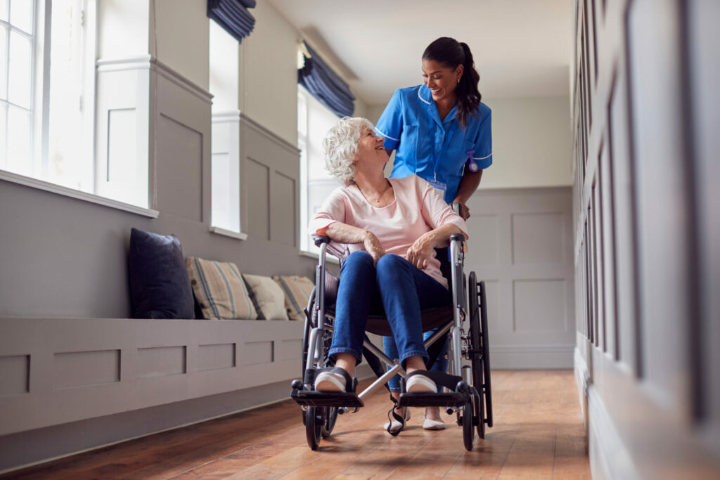An elderly woman in a wheelchair being cared for by a young caretaker